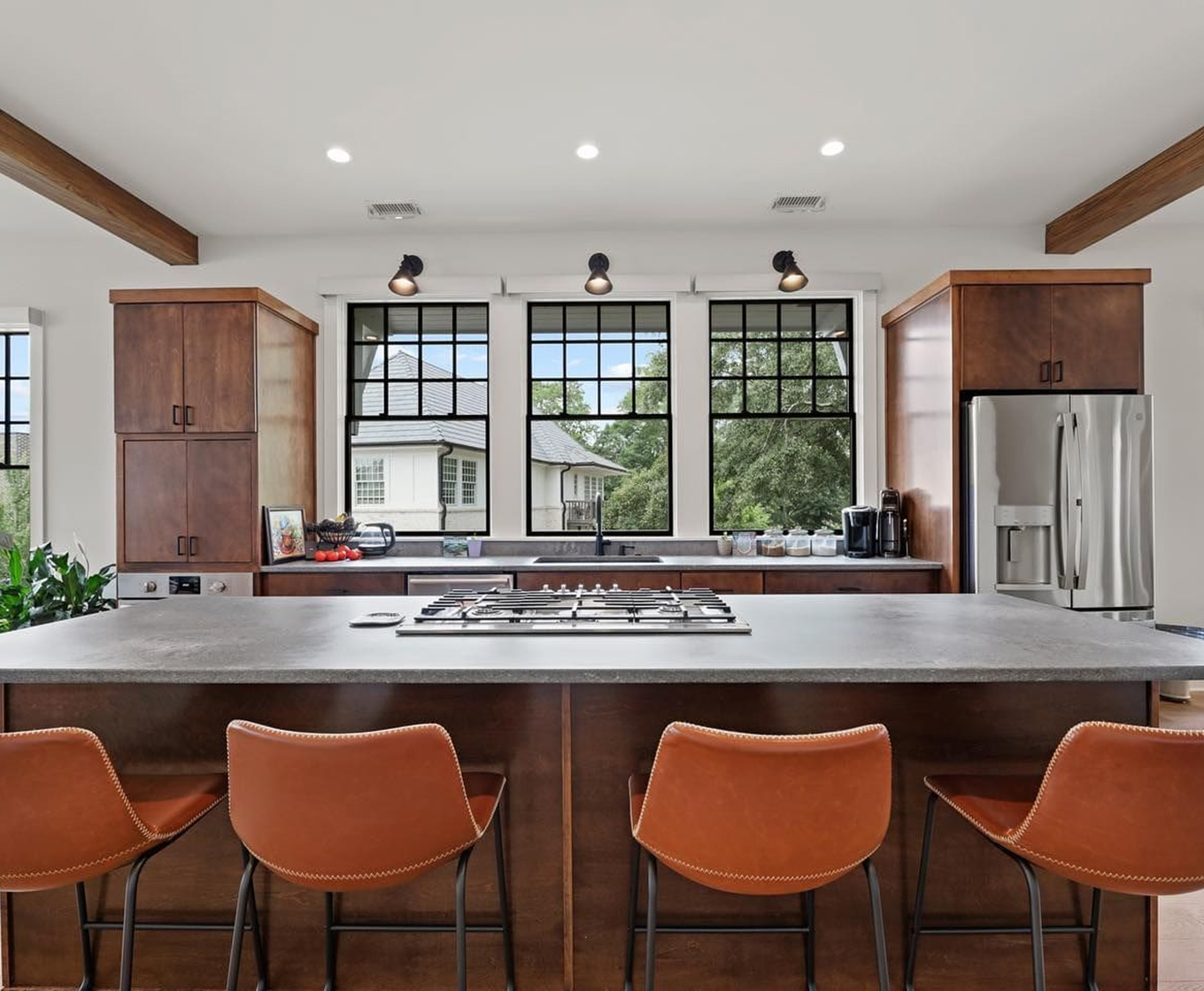 Real estate listing photo showing modern kitchen with large center island and barstools.